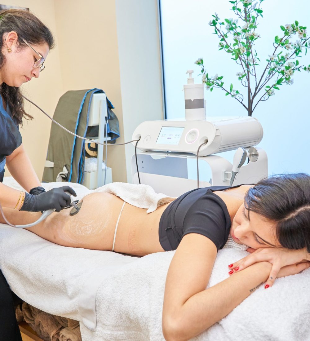 cosmetologist using radiofrequency device and removing stretch marks on female buttocks. Woman having skin tightening procedure in beauty salon. Hardware cosmetology concept.